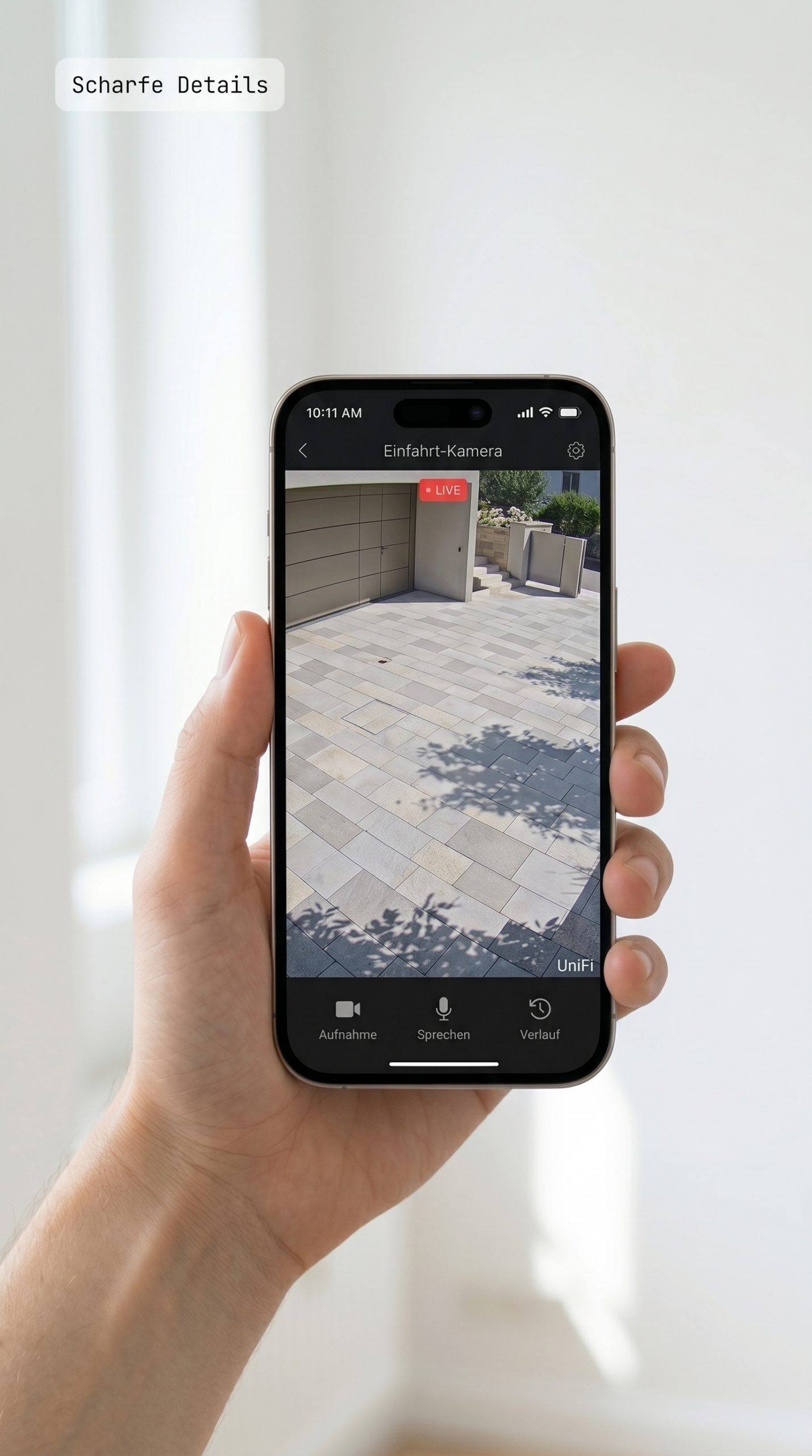 Smartphone in der Hand zeigt Live-Stream der Hauseinfahrt — Kameraüberwachung per App ohne Cloud-Zwang · e-team